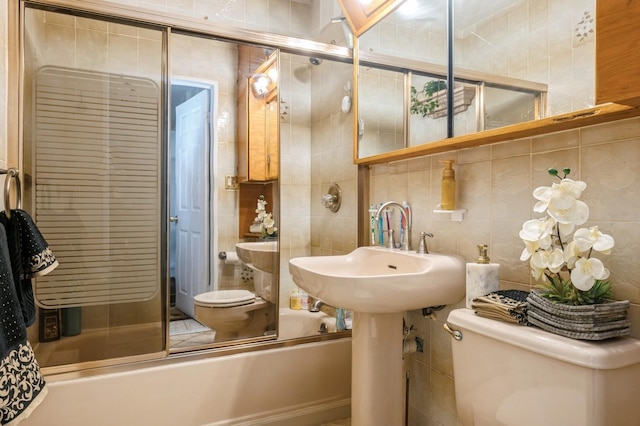 bathroom with toilet, bath / shower combo with glass door, decorative backsplash, and tile walls