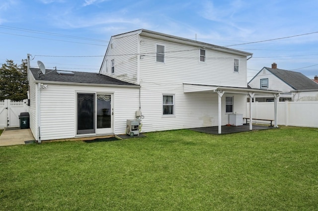 back of property featuring a fenced backyard, a gate, a lawn, and a patio