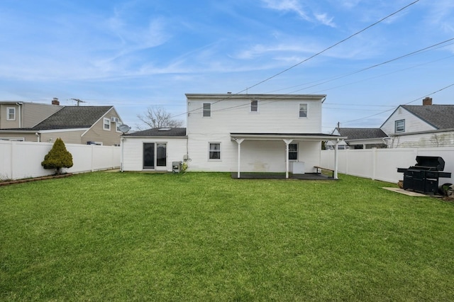 rear view of property with a fenced backyard and a lawn