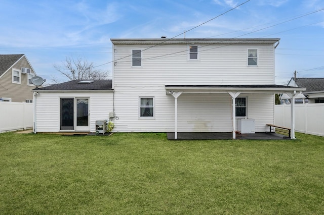 rear view of house with a fenced backyard and a lawn