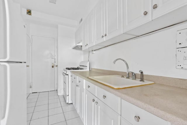 kitchen with under cabinet range hood, white appliances, a sink, white cabinetry, and light countertops