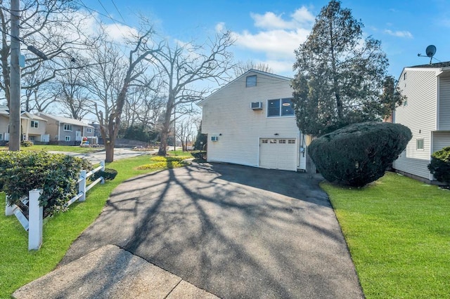 view of home's exterior featuring driveway, an attached garage, and a lawn