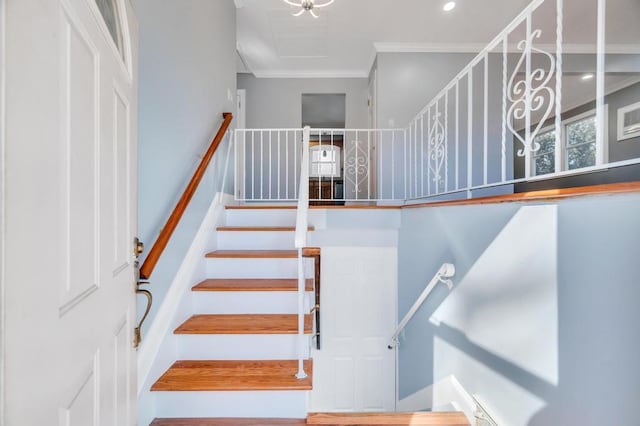 stairs featuring ornamental molding and recessed lighting