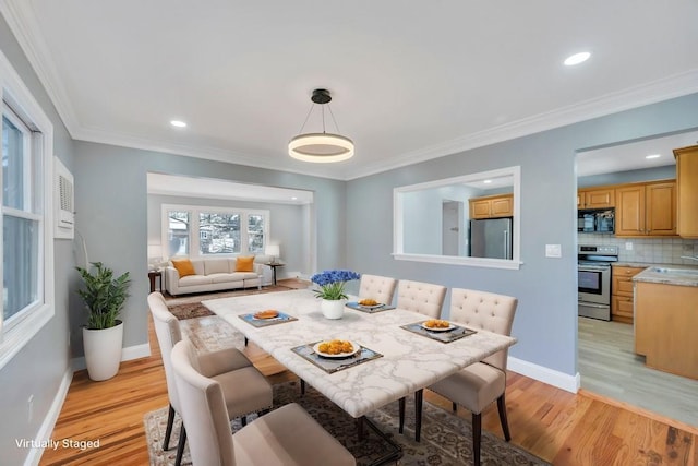 dining space featuring ornamental molding, light wood finished floors, recessed lighting, and baseboards