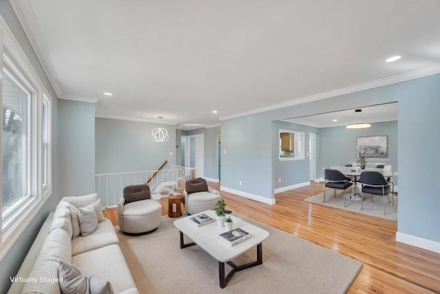 living room featuring light wood-style floors, baseboards, crown molding, and recessed lighting