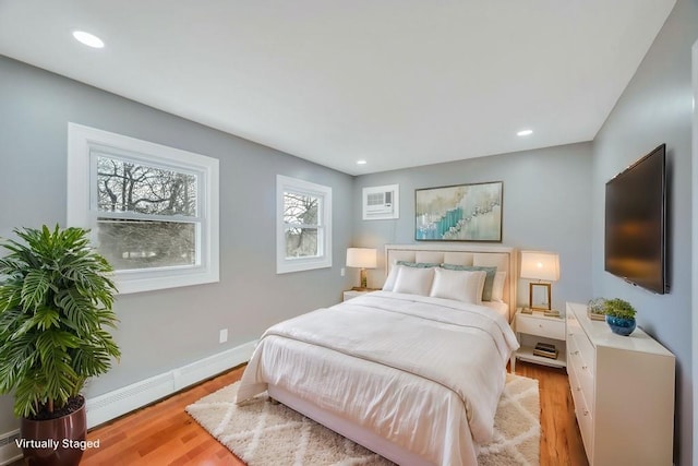 bedroom with light wood-type flooring, a baseboard radiator, baseboards, and recessed lighting