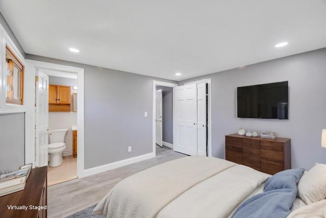 bedroom with recessed lighting, a closet, light wood-type flooring, and baseboards