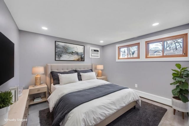 bedroom with recessed lighting, a wall unit AC, and baseboards