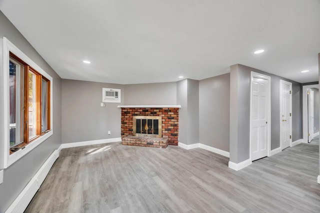 unfurnished living room featuring a baseboard radiator, recessed lighting, wood finished floors, baseboards, and a brick fireplace