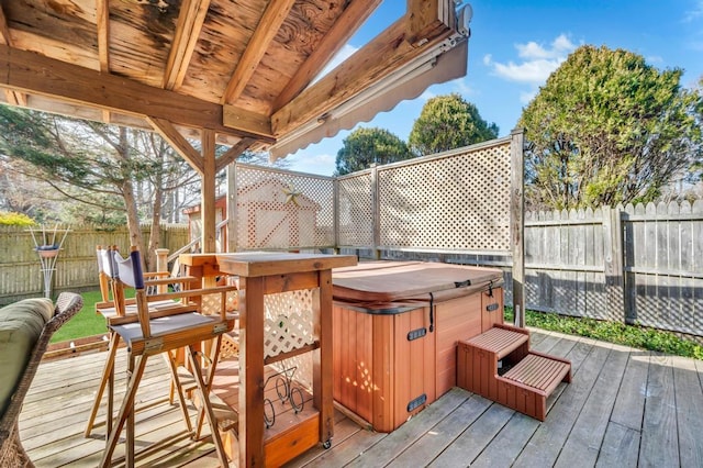 deck featuring a fenced backyard and a hot tub