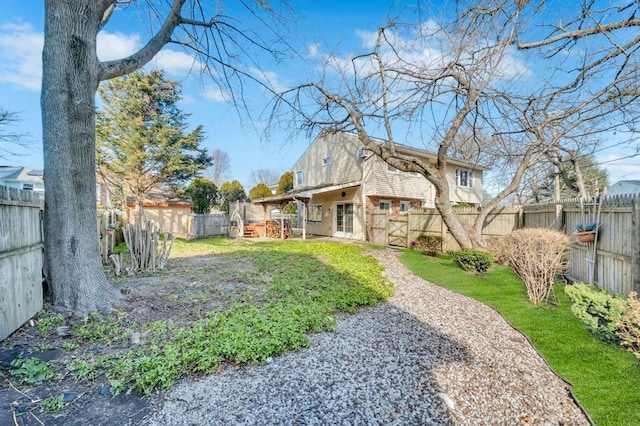 back of house featuring a fenced backyard, brick siding, a lawn, and a patio