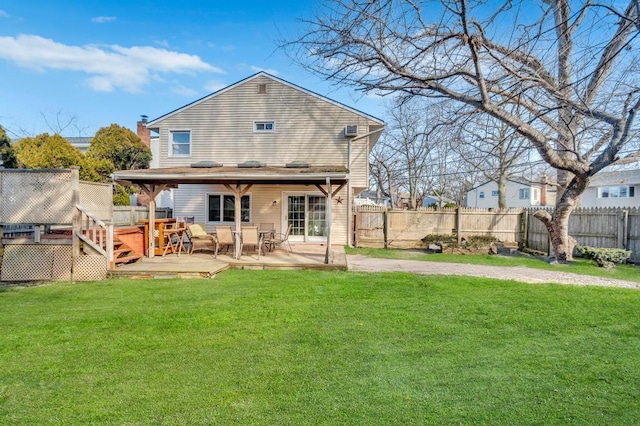 rear view of property featuring a lawn, a patio area, a fenced backyard, and a wooden deck