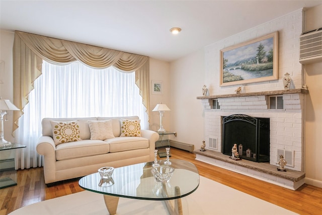 living area featuring a fireplace, wood finished floors, and visible vents