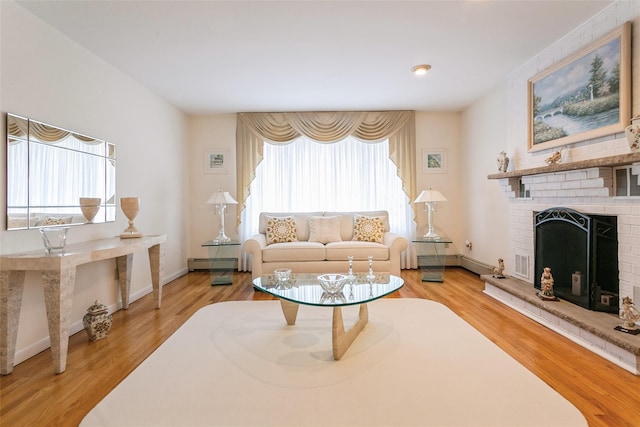 living room with a baseboard radiator, a fireplace, a wealth of natural light, and wood finished floors