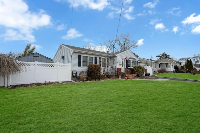 ranch-style home with fence, driveway, and a front lawn