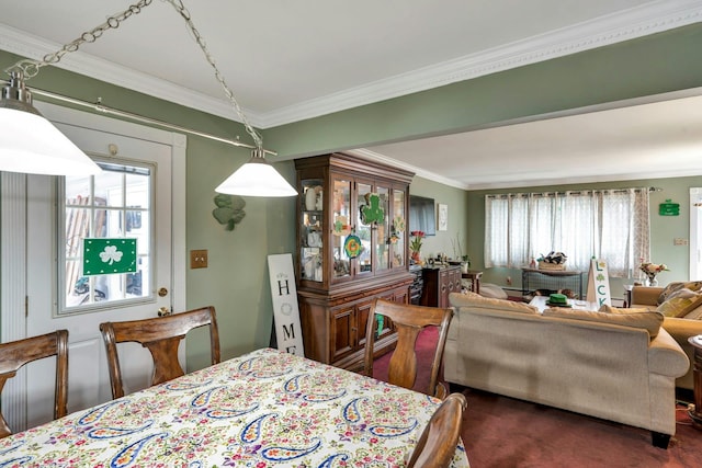 dining room featuring crown molding, dark colored carpet, and plenty of natural light