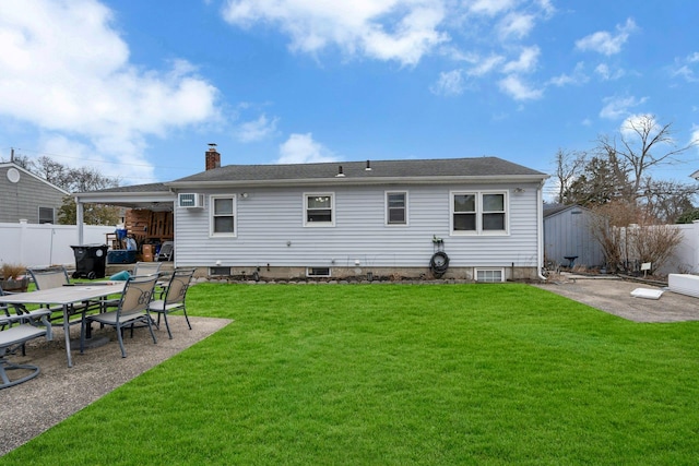 rear view of property featuring a patio, a yard, a chimney, and a fenced backyard