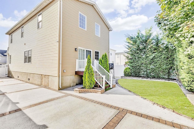 view of side of home with a yard and a patio area