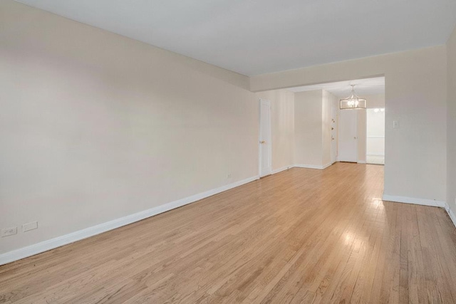 empty room featuring light wood finished floors and baseboards