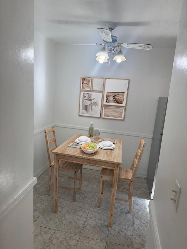 dining area featuring ceiling fan and baseboards