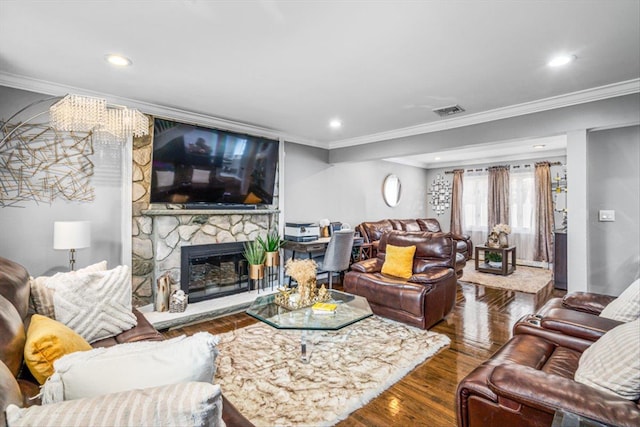 living area with visible vents, wood finished floors, crown molding, a fireplace, and recessed lighting