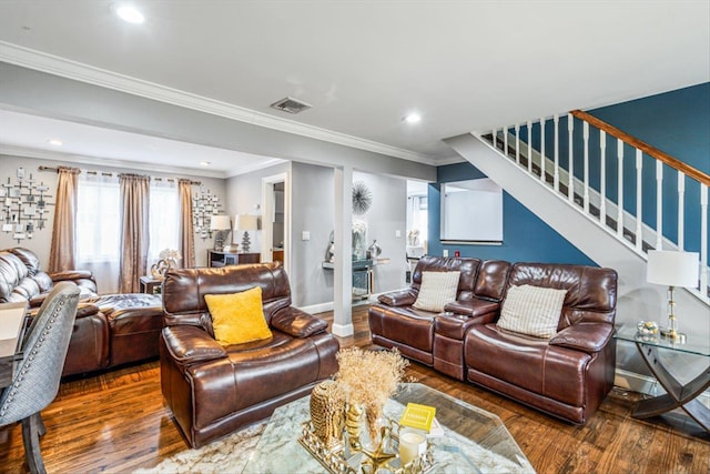 living area with visible vents, baseboards, ornamental molding, stairway, and wood-type flooring