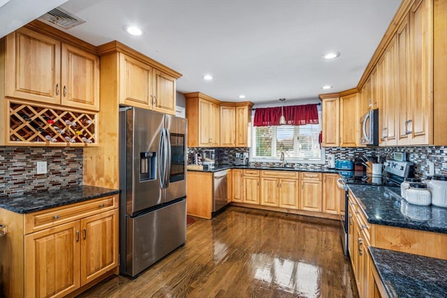 kitchen featuring appliances with stainless steel finishes, dark wood finished floors, and backsplash