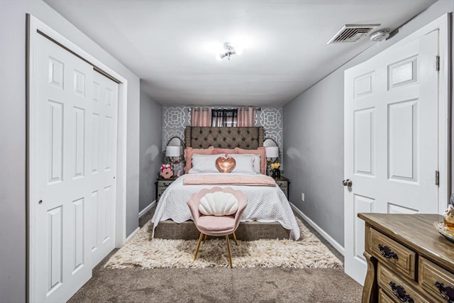 bedroom with an accent wall, carpet, visible vents, and baseboards