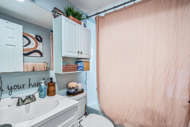 bathroom with toilet, shower / bath combination with curtain, and vanity