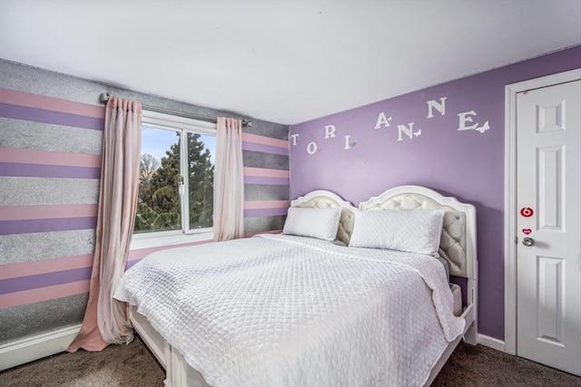 bedroom featuring dark colored carpet and baseboards