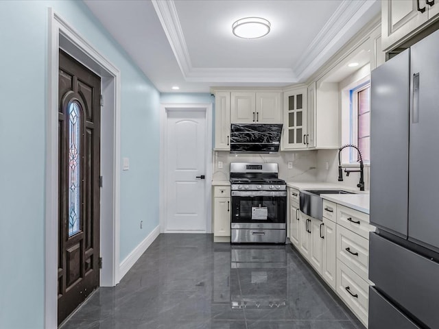 kitchen with crown molding, light countertops, decorative backsplash, appliances with stainless steel finishes, and a sink