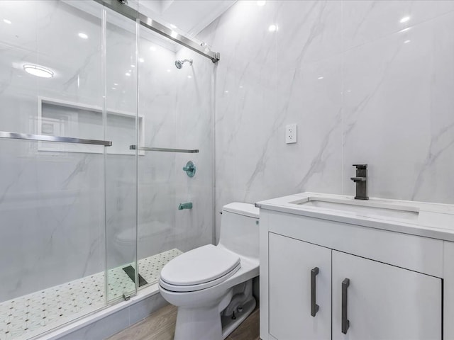 full bath with toilet, wood finished floors, vanity, tile walls, and a marble finish shower