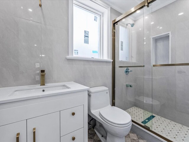 full bathroom with toilet, a shower stall, crown molding, and tile walls