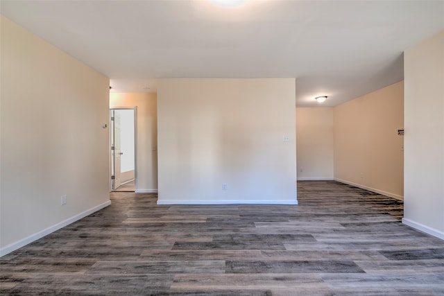 empty room featuring baseboards and wood finished floors