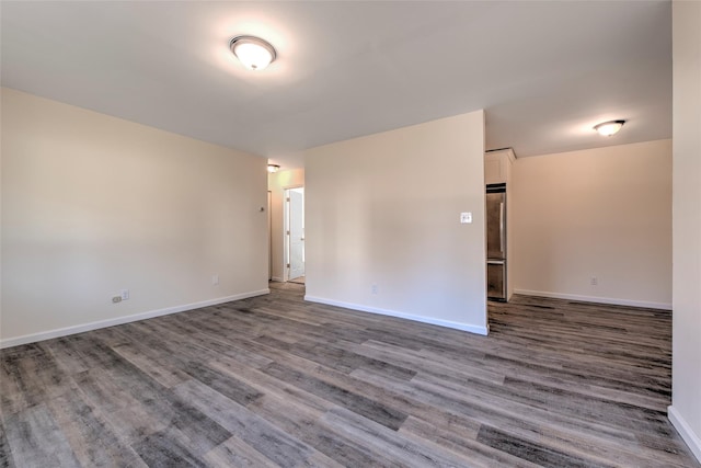 empty room with baseboards and wood finished floors