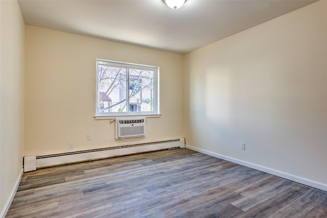 unfurnished room featuring wood finished floors, a baseboard radiator, a wall unit AC, and baseboards