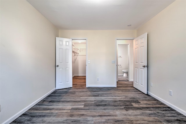 unfurnished bedroom with baseboards and dark wood finished floors