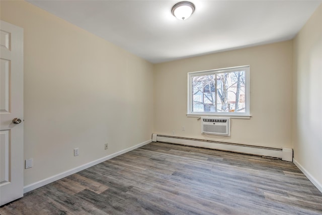 unfurnished room with a baseboard heating unit, an AC wall unit, baseboards, and wood finished floors