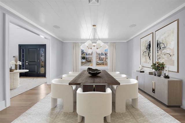 dining room with visible vents, light wood-style floors, wood ceiling, and a notable chandelier