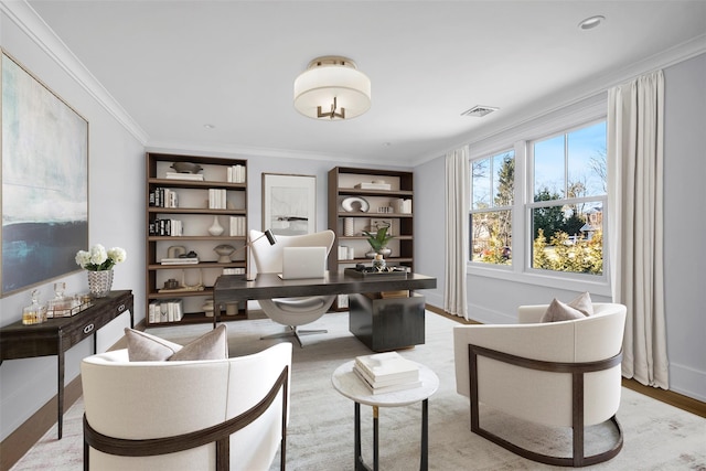 sitting room featuring light wood-style floors, baseboards, visible vents, and ornamental molding