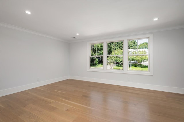 spare room with crown molding, recessed lighting, light wood-type flooring, and baseboards