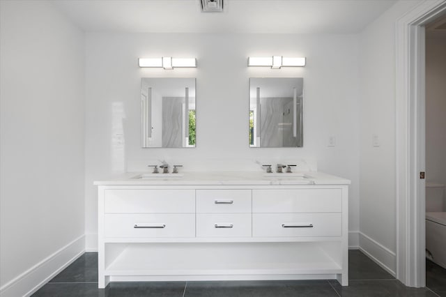 full bathroom with double vanity, baseboards, toilet, a walk in shower, and a sink