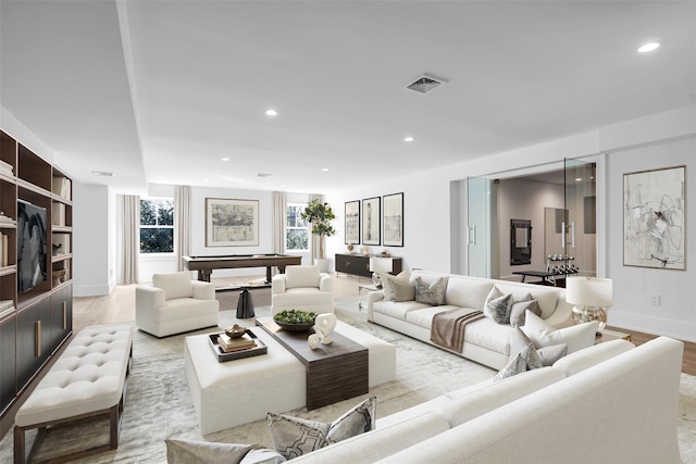 living room with light wood-type flooring, visible vents, and recessed lighting