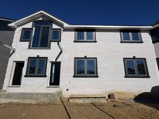 view of front facade with entry steps and brick siding