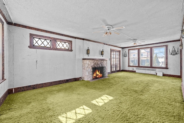 unfurnished living room with carpet floors, radiator heating unit, and a wealth of natural light