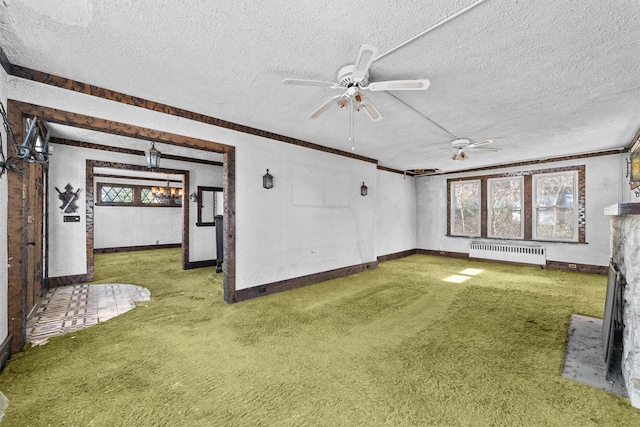 unfurnished living room with radiator, ceiling fan, a textured ceiling, and carpet flooring