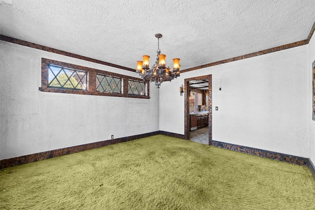 empty room with a textured ceiling, a textured wall, a notable chandelier, carpet floors, and baseboards