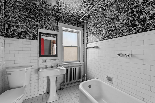 full bath with toilet, tile walls, a washtub, and radiator