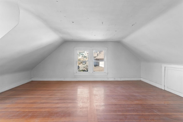 additional living space featuring lofted ceiling and wood finished floors