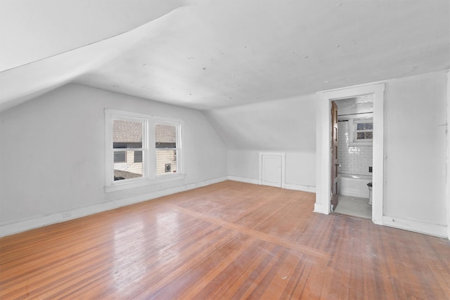 additional living space featuring lofted ceiling, baseboards, and hardwood / wood-style floors